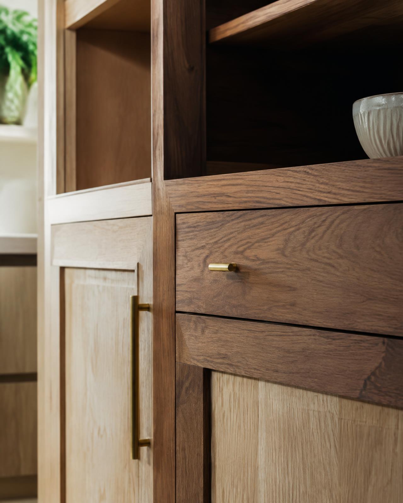 Close detail of walnut and oak cabinetry with brass hardware
